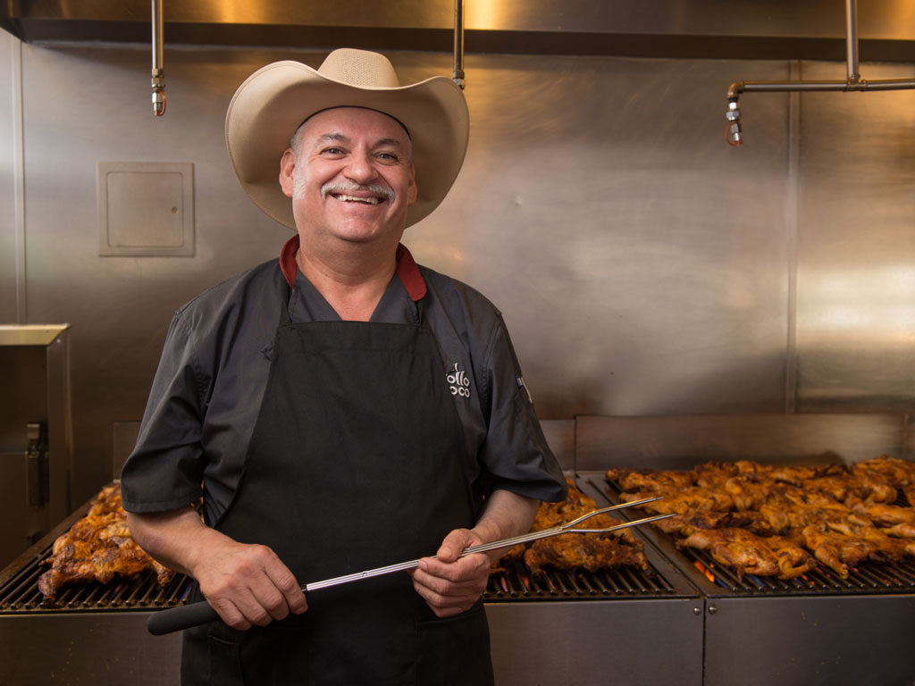 Chef with cowboy hat grilling chicken
